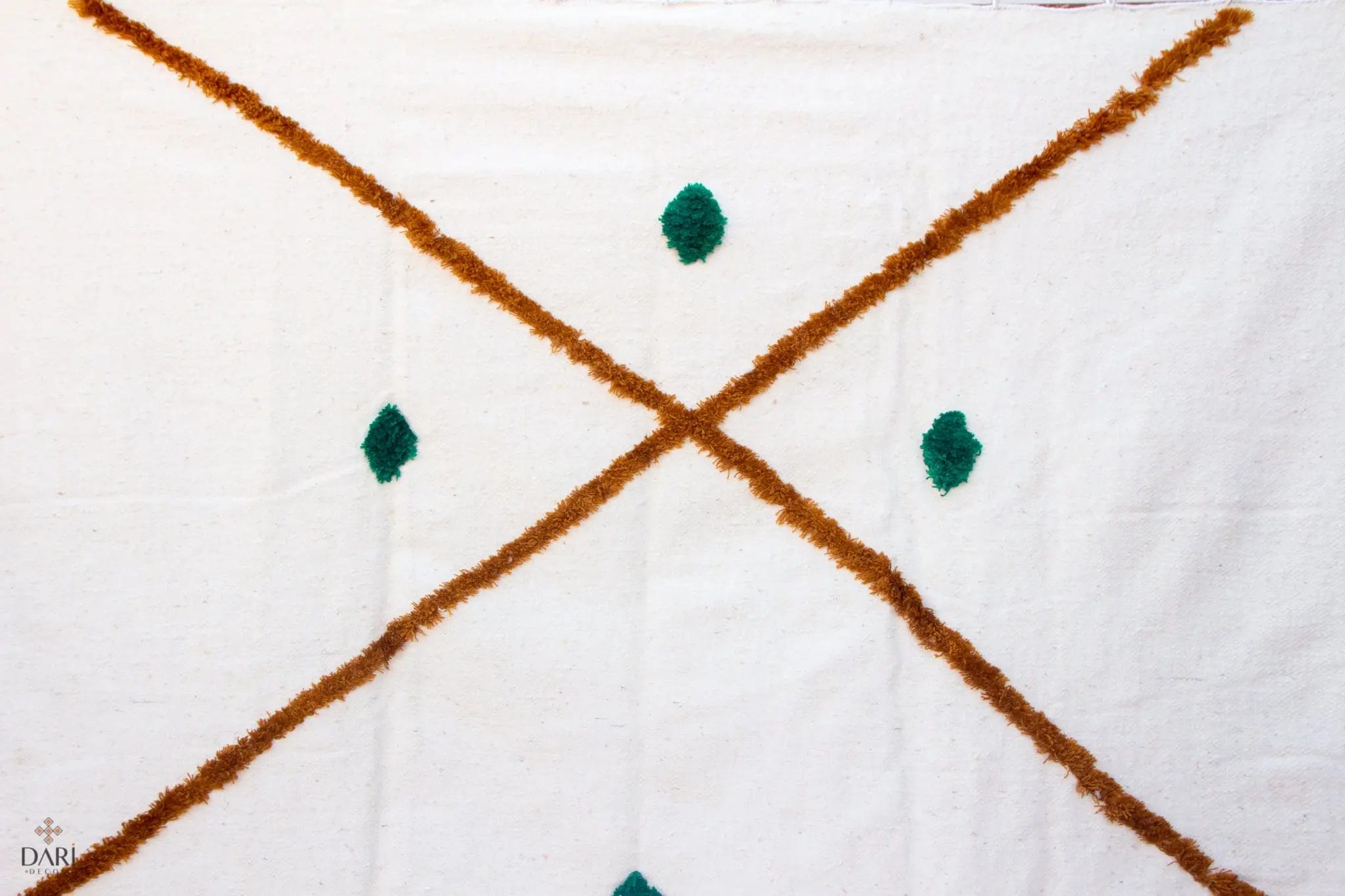 De witte stof heeft een bruin kruispatroon met vier groene ruitvormen.