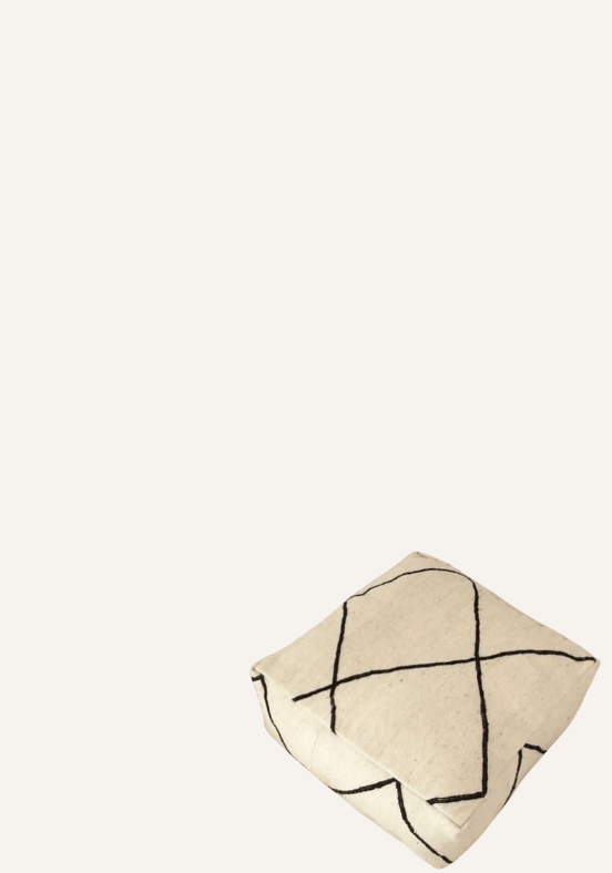 Een beige vloerkussen met een zwart kruispatroon op een effen achtergrond.