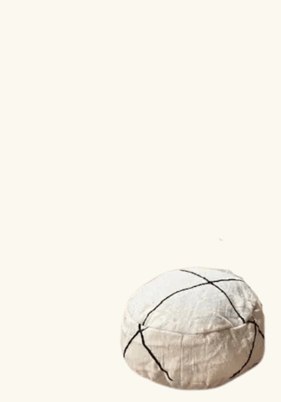 Een ronde poef van stof met zwarte, kruisende lijnen op een witte achtergrond.